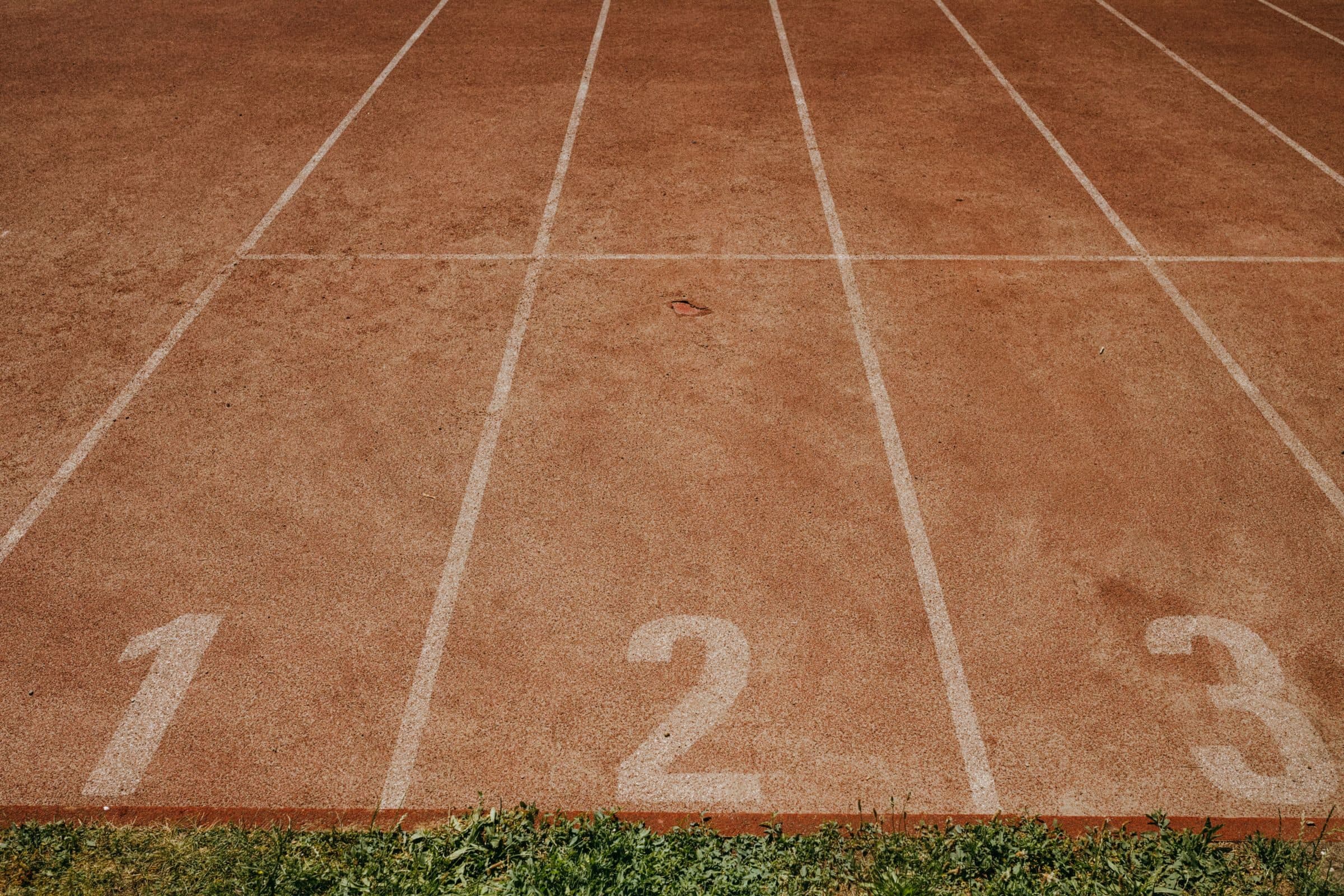 Números 1, 2 e 3 pintados no início das raias de uma pista de atletismo